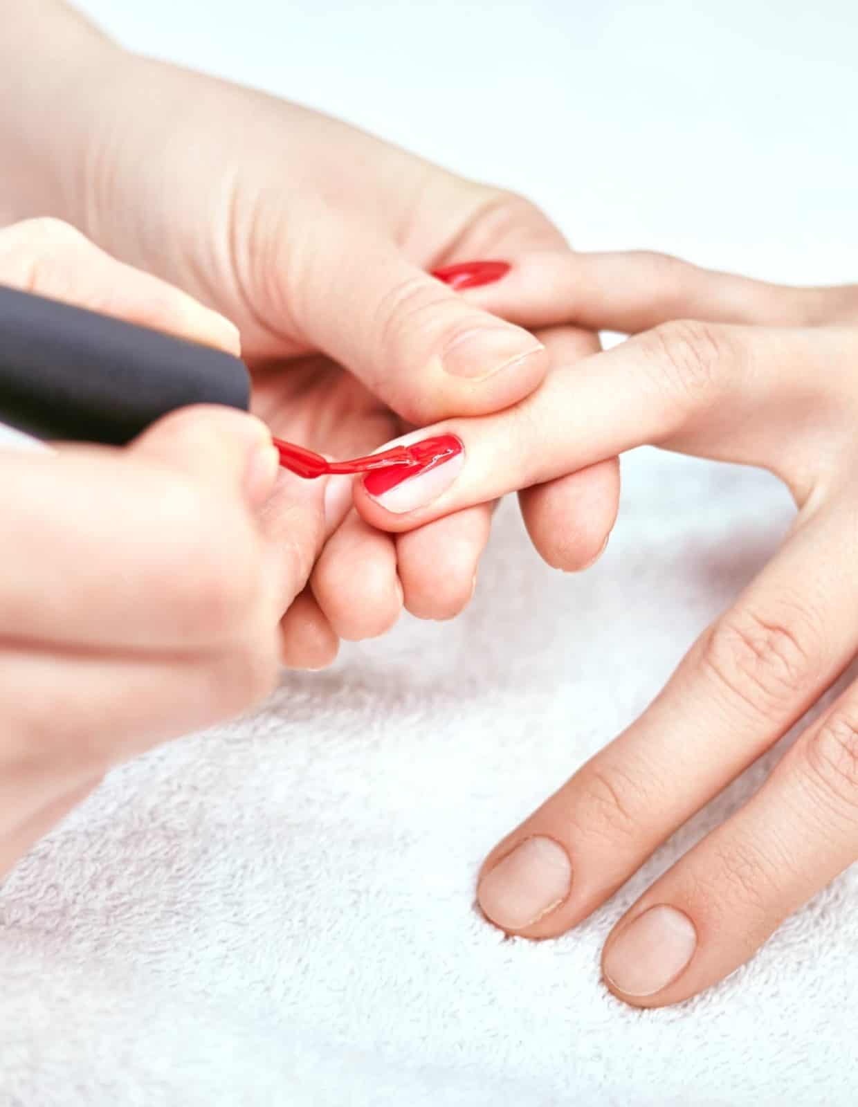 a close-up of hands receiving a nail polish treatment