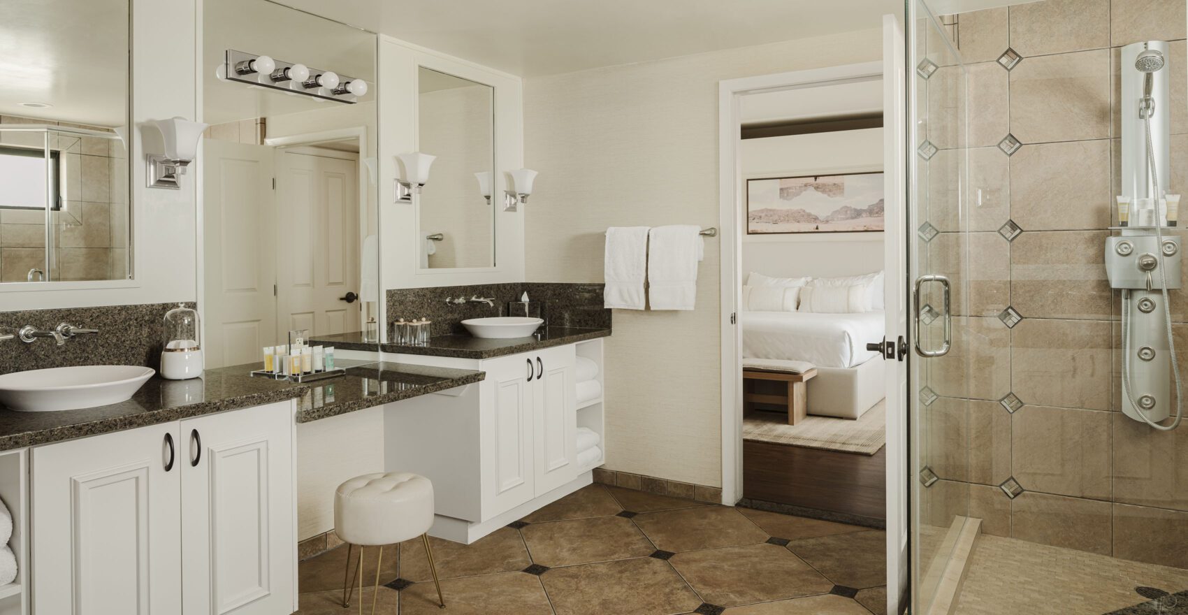 A clean and modern bathroom with a double vanity, shower, and tiled floor.