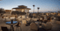 Elevated rooftop terrace with modern lounge furniture and panoramic views of Phoenix and Camelback Mountain at twilight.